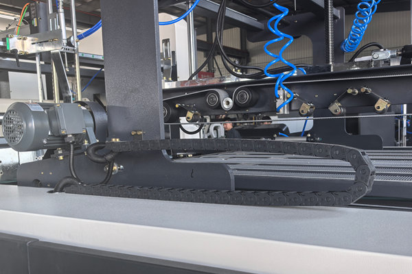 Flexible plastic cable drag chain installed on automated assembly line machinery next to drive motor