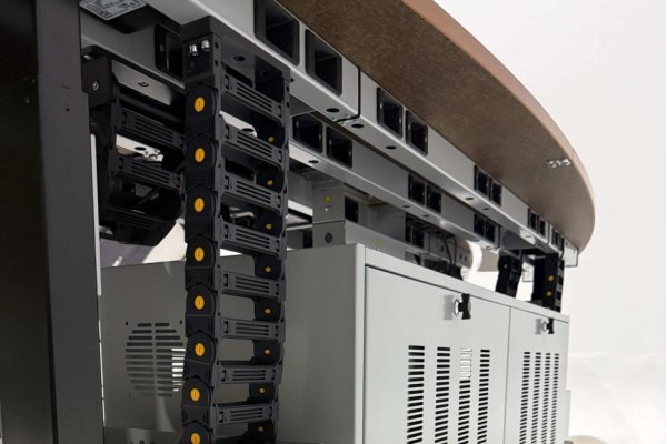 Vertical S-shape flexible cable carrier chain installed under control room console desk for cable protection