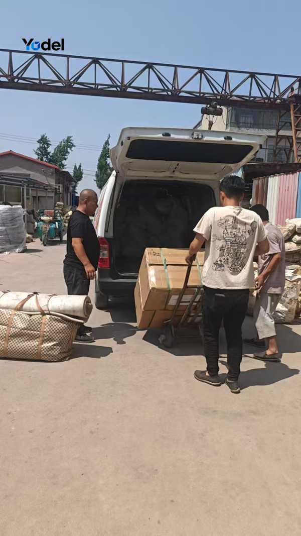 Workers loading packaged drag chain 15x30 boxes onto transport vehicle for shipping
