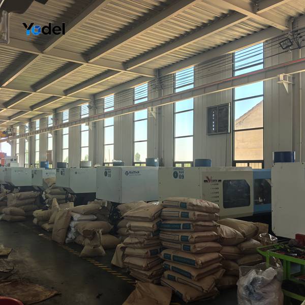 Industrial injection molding machines and stacked PA66 raw material bags in drag chain manufacturing factory