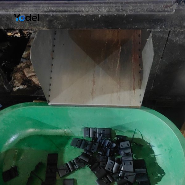 reshly molded plastic drag chain crossbars and links falling into collection basin from injection machine