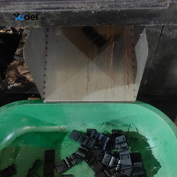 Automated injection molding machine chute dropping newly molded black nylon links for plastic cable chain 25x38
